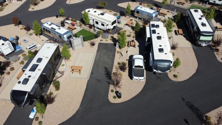 Comparison of fifth wheel and travel trailer RVs parked in nature showing different towing styles and spacious layouts for outdoor camping
