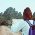 Young traveler working remotely with backpack symbolizing no-experience travel jobs with paid accommodation and travel benefits