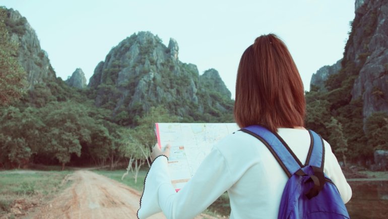 Young traveler working remotely with backpack symbolizing no-experience travel jobs with paid accommodation and travel benefits