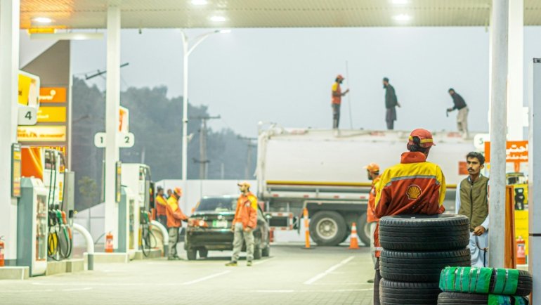 Bert's Travel Plaza highway rest stop with fuel pumps, trucks parking, and travelers using clean facilities