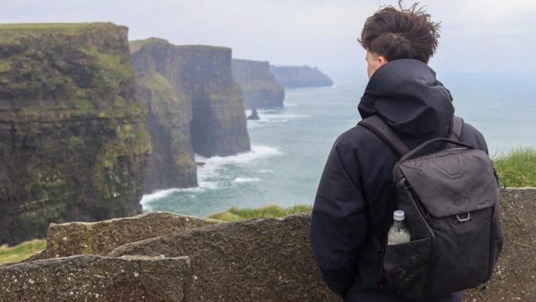 Solo traveler exploring scenic Irish coastline and countryside during a peaceful adventure in Ireland