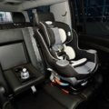 Parent installing a child car seat properly in the car for safe travel with children
