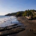 Sunny El Salvador beach with surfers and clear blue sky during the dry season