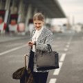 Stylish woman carrying a practical handbag while traveling in a city, combining fashion and function