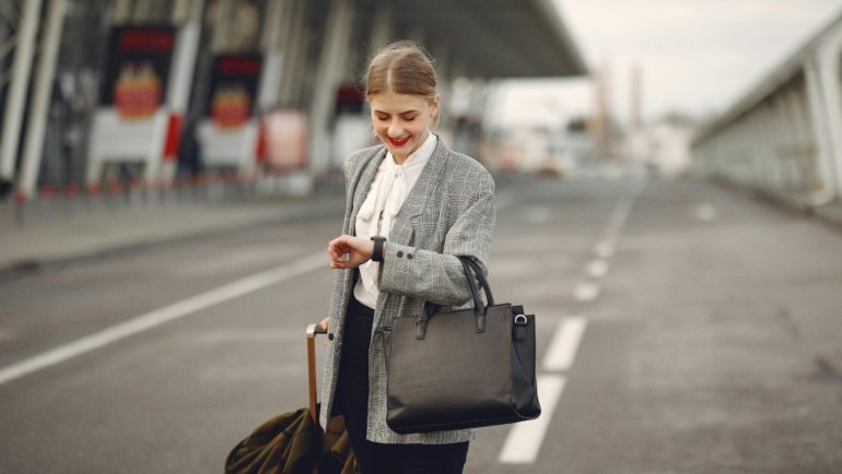 Stylish woman carrying a practical handbag while traveling in a city, combining fashion and function