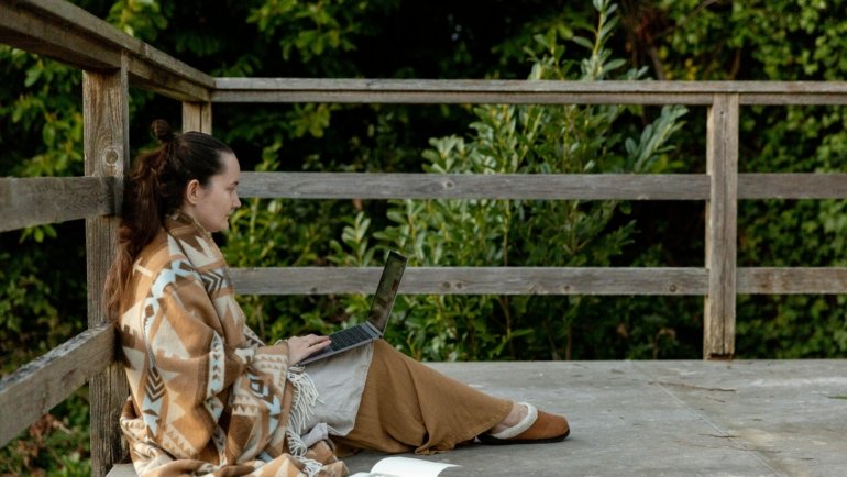 Traveler wrapped in heated travel blanket enjoying warmth and comfort during trip