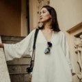 Petite woman wearing a tailored travel outfit with layering, comfortable shoes, and accessories, ready for a stylish and practical trip