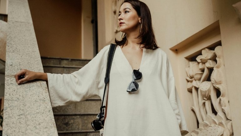 Petite woman wearing a tailored travel outfit with layering, comfortable shoes, and accessories, ready for a stylish and practical trip