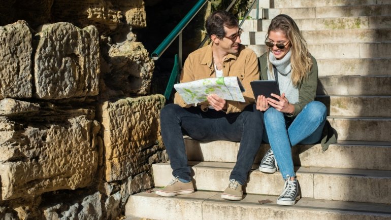 Happy travelers reading Gateway Travel reviews to plan their trip with confidence