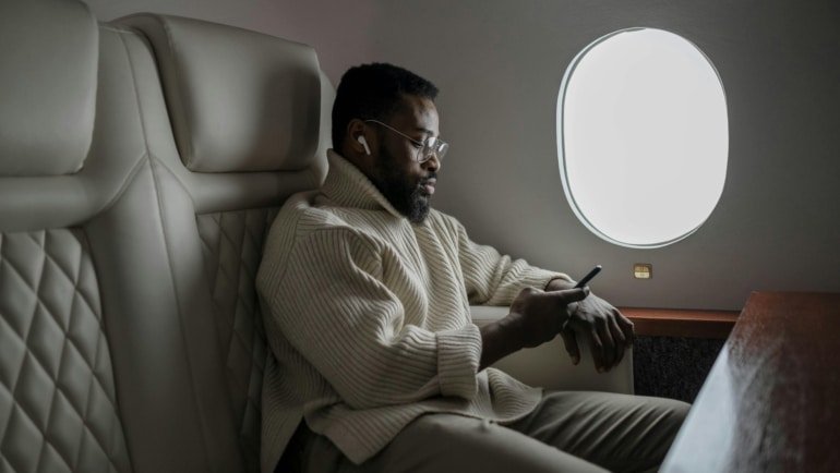 Traveler comfortably using a travel pillow on an airplane seat for neck support and restful flight experience