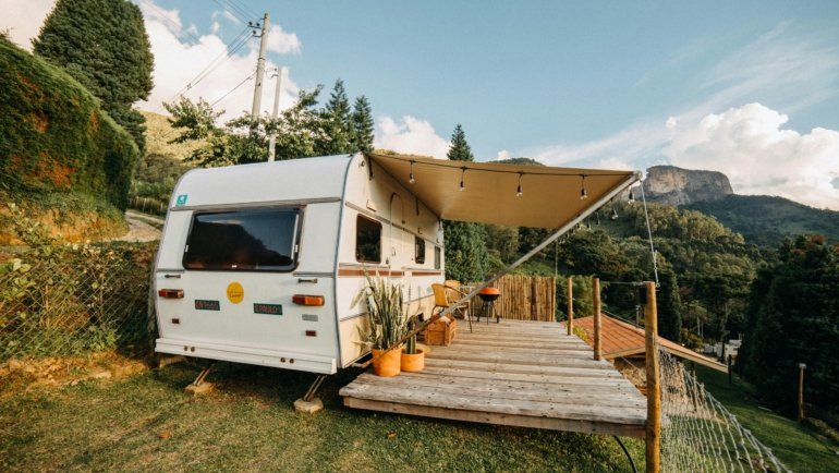 Grand Design Reflection modern travel trailer parked in nature with outdoor living setup
