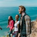 Group of joyful travelers laughing outdoors enjoying funny moments during their trip