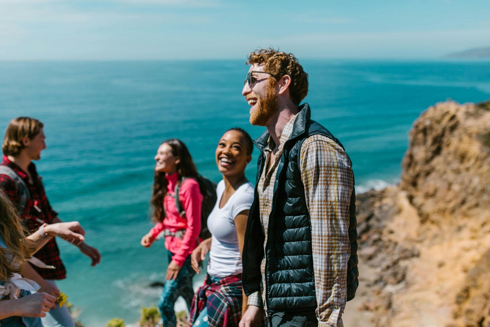 Group of joyful travelers laughing outdoors enjoying funny moments during their trip