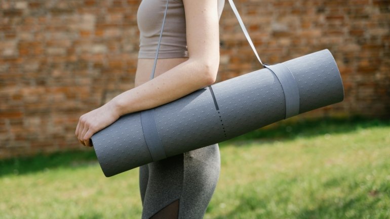 Foldable travel yoga mat neatly folded and packed for easy transport, perfect for travelers seeking portable and durable yoga gear.