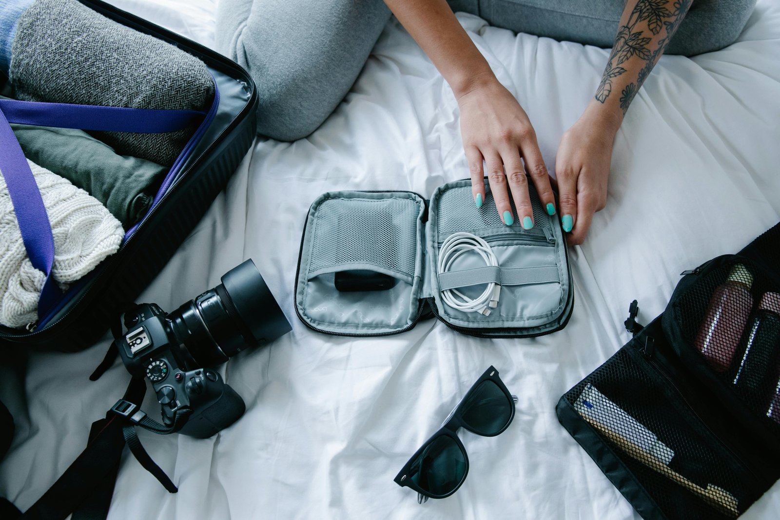 Woman packing travel accessories including organizer bags, compression cubes, and crossbody bag for a comfortable and stylish trip