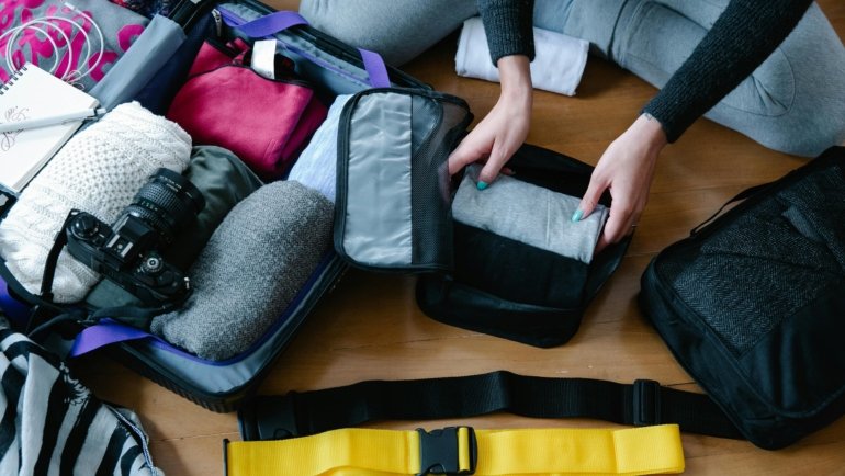 Female traveler organizing stylish travel accessories for an enjoyable and comfortable trip