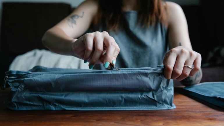 Large organized cosmetic travel bag with skincare and makeup products for travel