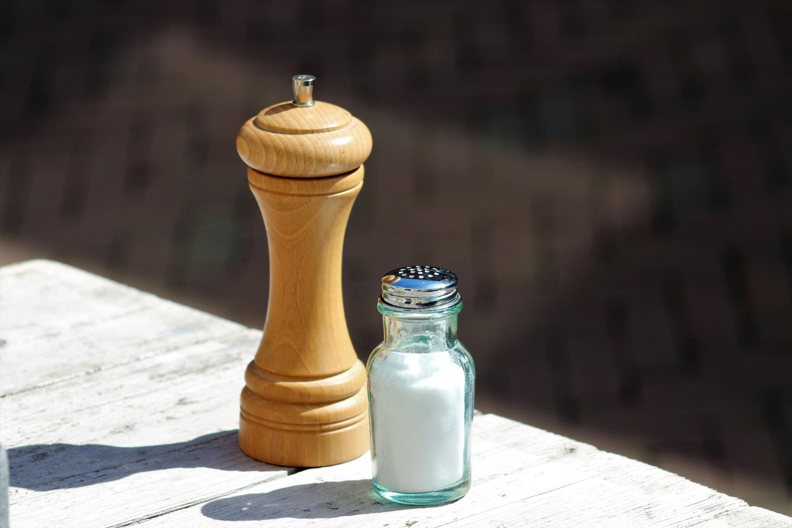 Compact travel salt and pepper shakers used outdoors during a camping meal for easy seasoning on the go