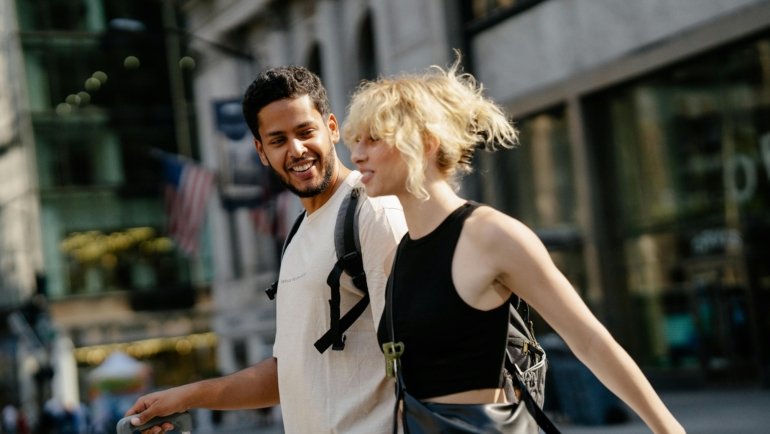 Friendly travel companion walking through a city street providing safety and local guidance for a traveler