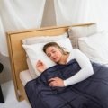 Traveler resting comfortably wrapped in a cozy weighted blanket during travel, promoting relaxation and better sleep on the road