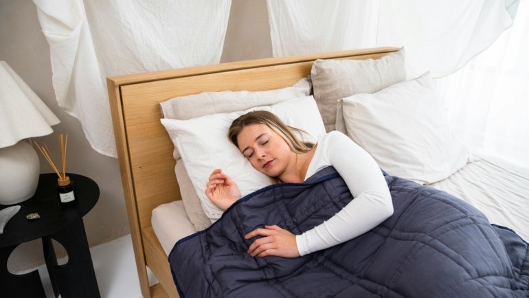 Traveler resting comfortably wrapped in a cozy weighted blanket during travel, promoting relaxation and better sleep on the road