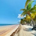 Sunny Belize beach in March with clear skies and turquoise waters ideal for snorkeling and outdoor activities