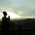 Traveler praying outdoors seeking spiritual guidance and protection during a peaceful journey