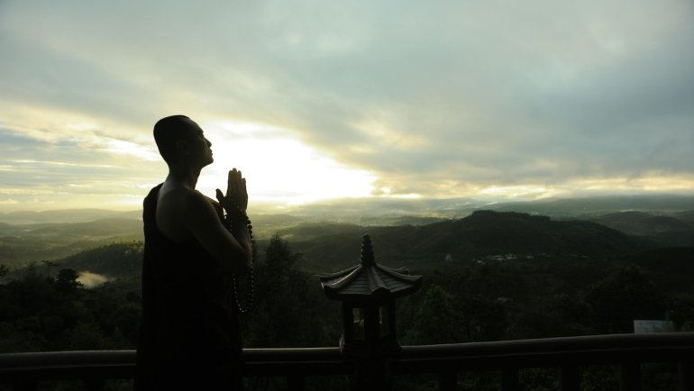 Traveler praying outdoors seeking spiritual guidance and protection during a peaceful journey