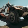 Toyota Tacoma equipped with long travel suspension kit driving over rocky off-road trail