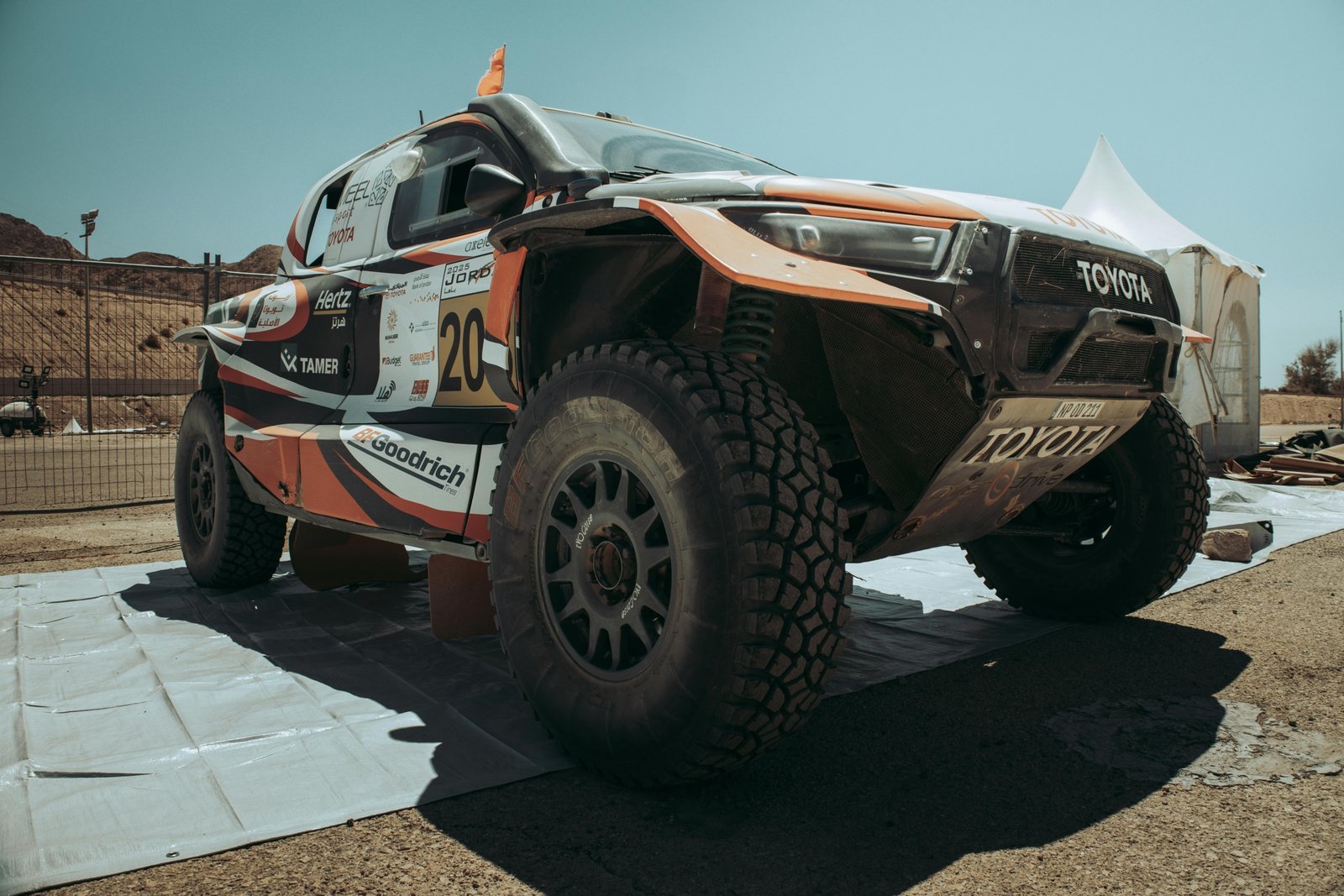 Toyota Tacoma equipped with long travel suspension kit driving over rocky off-road trail