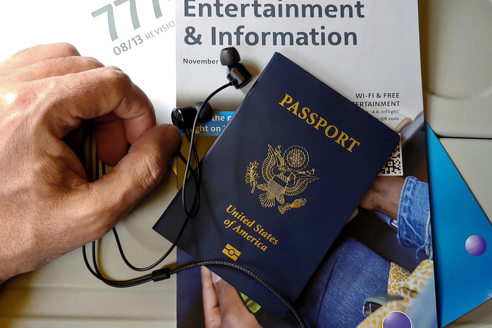 Wired noise cancelling earbuds in use by traveler on airplane for noise reduction and comfort during flight
