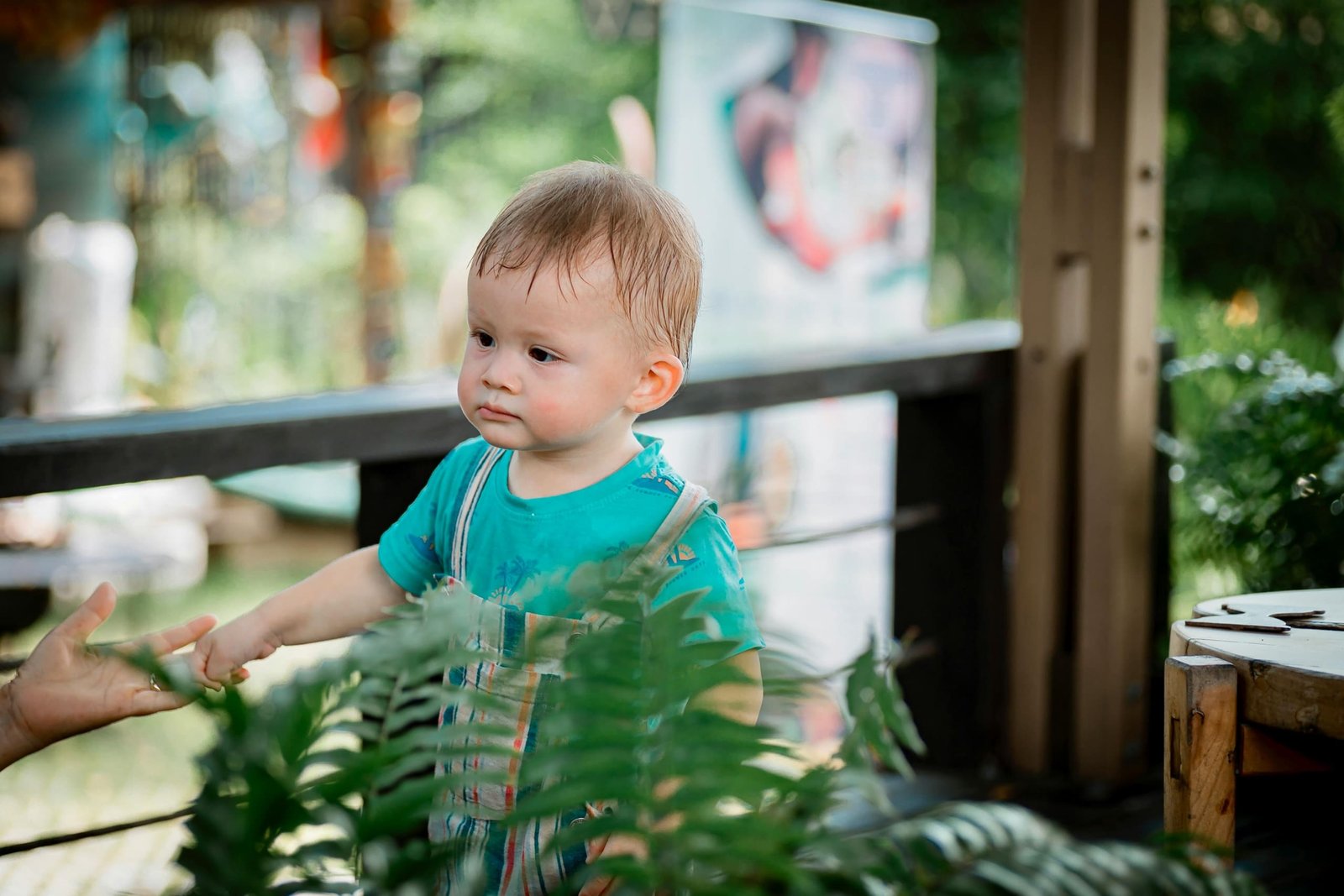 Toddler playing safely in a portable travel playpen outdoors during family trip