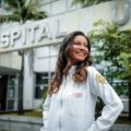 Allied health professional preparing for a travel healthcare assignment with a suitcase in hospital corridor