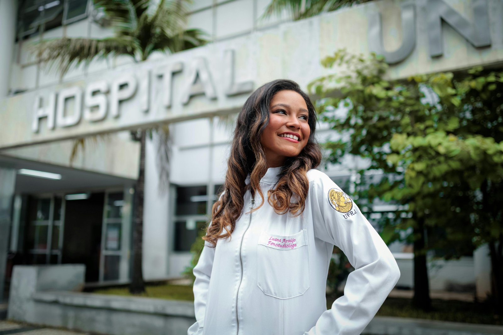Allied health professional preparing for a travel healthcare assignment with a suitcase in hospital corridor