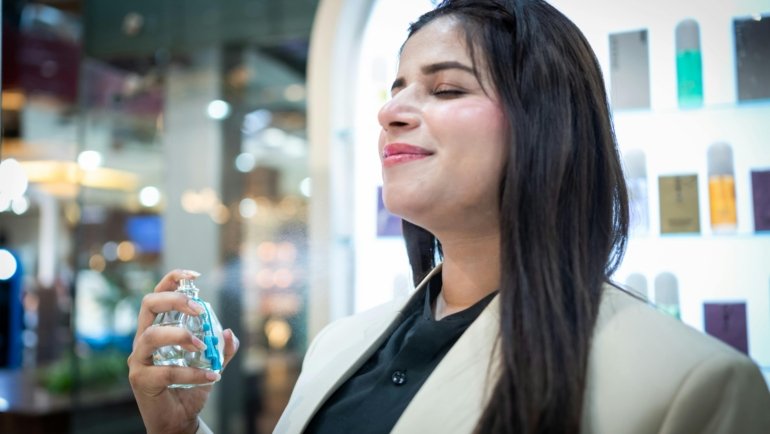 Young woman holding a compact travel perfume bottle, embodying modern and bold travel fragrance inspired by Billie Eilish