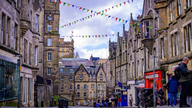 Crowd enjoying summer festival with historic Edinburgh buildings in the background