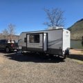 Lightweight 3500 lb travel trailer parked at scenic campsite with family enjoying outdoor camping experience