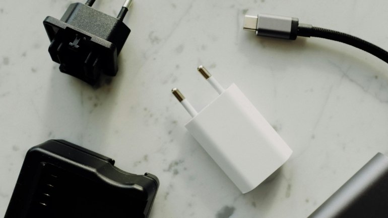 Compact travel adapter plug compatible with type C and F sockets for charging electronic devices safely in Spain