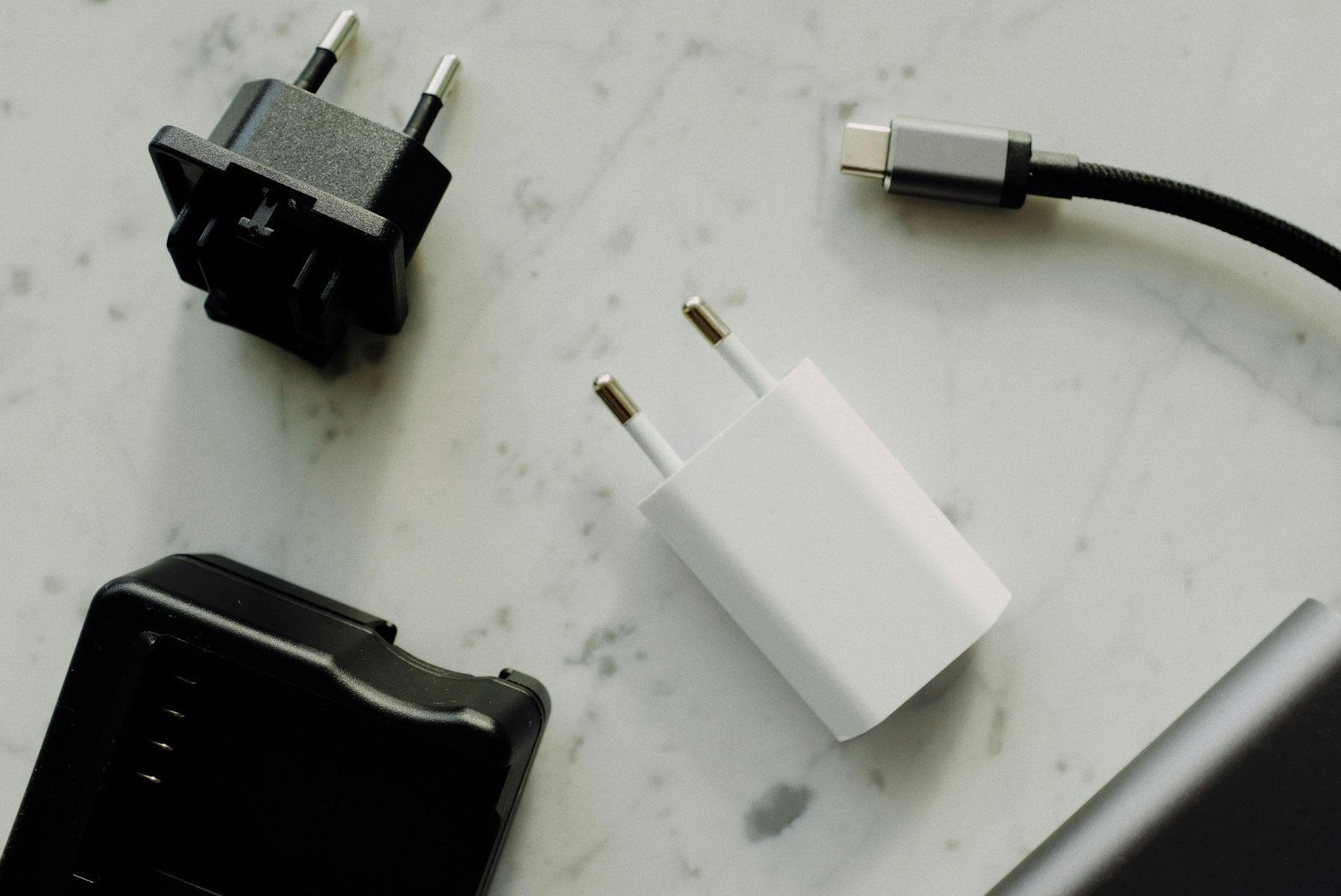 Compact travel adapter plug compatible with type C and F sockets for charging electronic devices safely in Spain