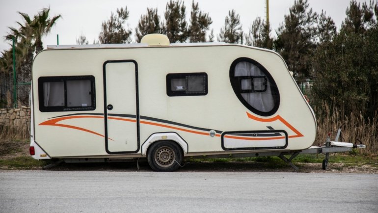 Apex travel trailer parked in nature, showcasing a compact and lightweight RV ideal for road trips and camping
