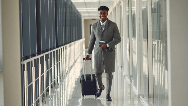 Man wearing wrinkle-resistant travel suit at airport, combining style and comfort for business travel