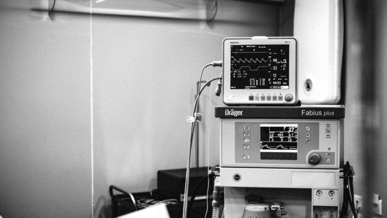 Traveling anesthesia technician setting up anesthesia equipment in hospital operating room