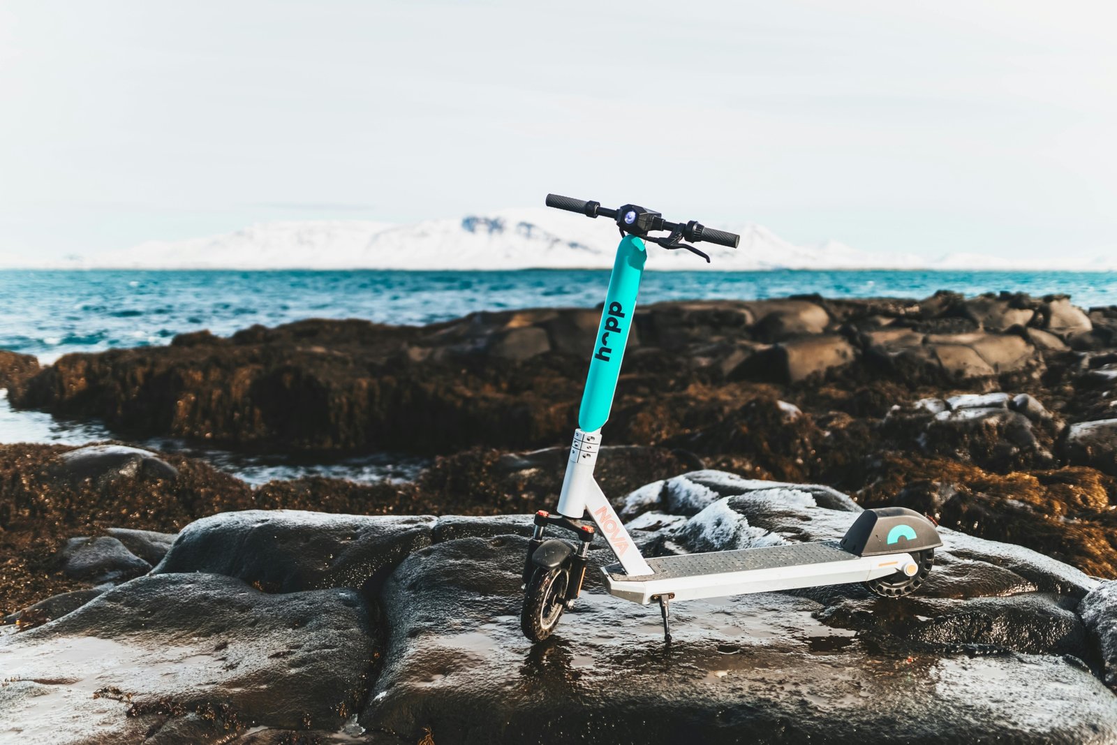 Foldable travel scooter folded and ready to carry in a bright outdoor travel environment