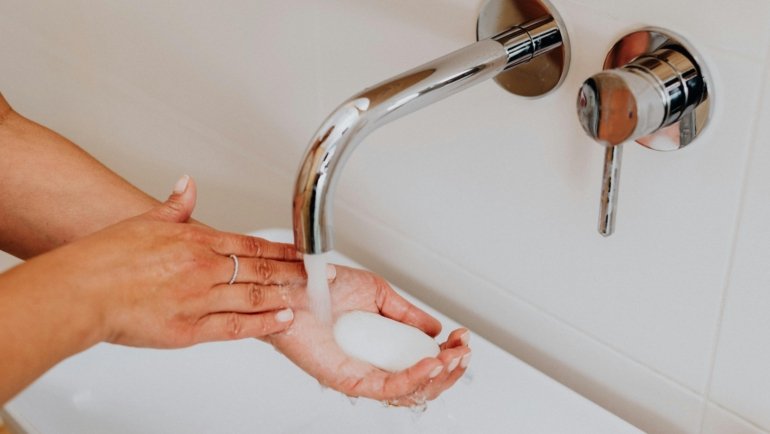 Traveler dissolving lightweight soap sheets in hands for hygienic and convenient handwashing during a trip