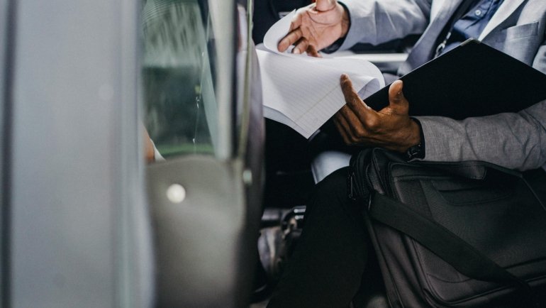 Person carefully reviewing travel documents and probation papers before traveling with official permission