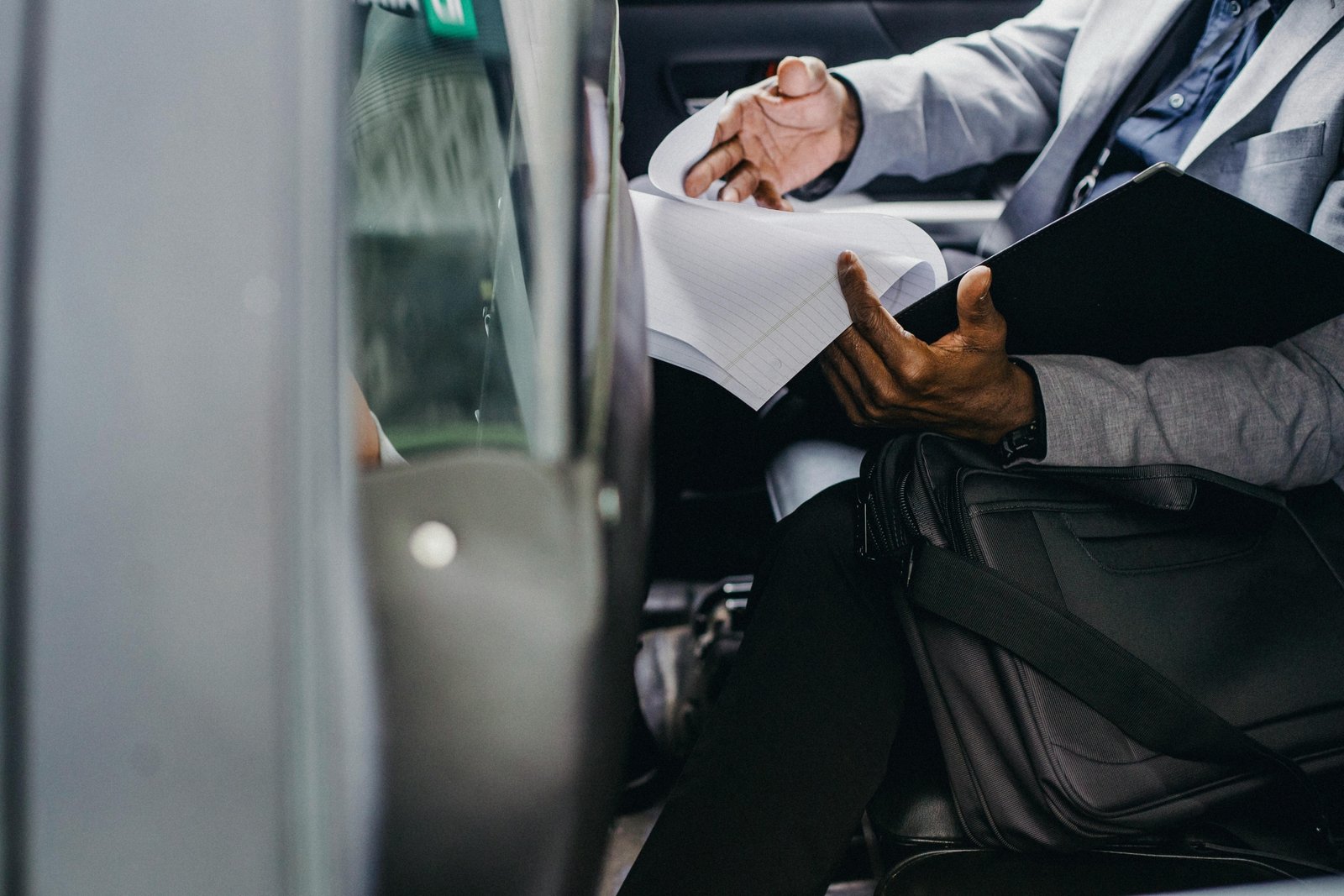 Person carefully reviewing travel documents and probation papers before traveling with official permission