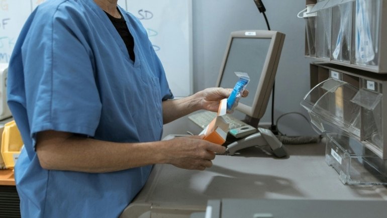 Pharmacy technician at work in a hospital pharmacy preparing medication, representing travel pharmacy technician jobs and flexible healthcare careers