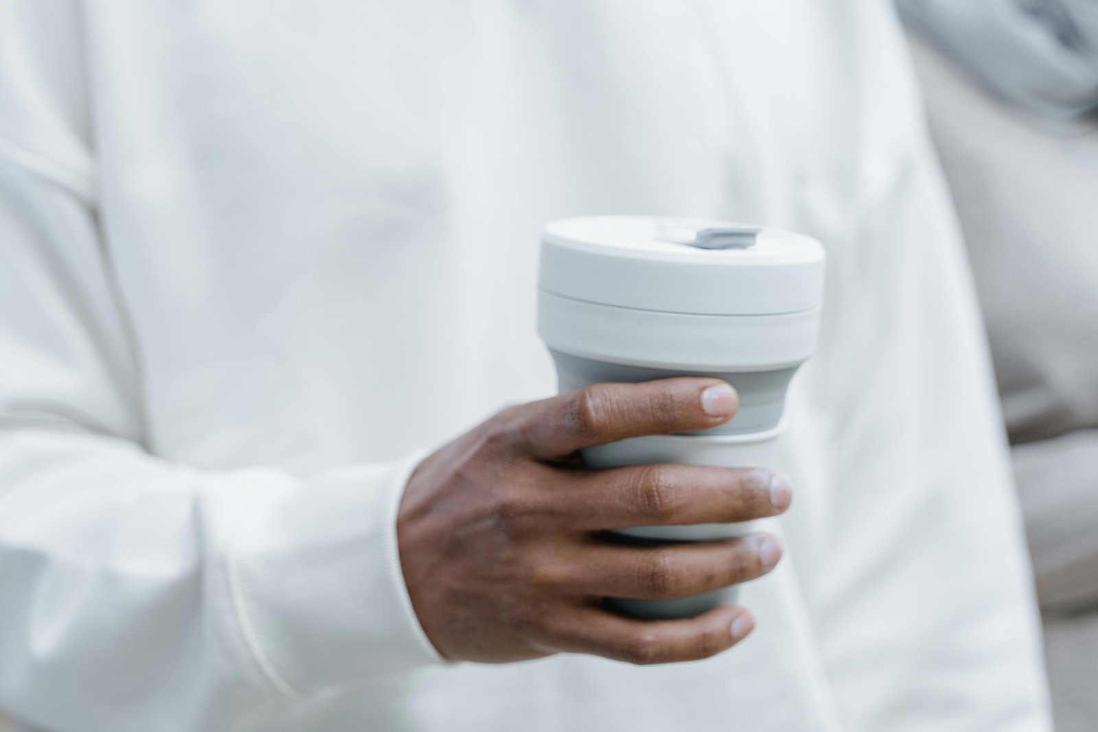 Compact collapsible travel cup used outdoors by a traveler for eco-friendly hydration on the go