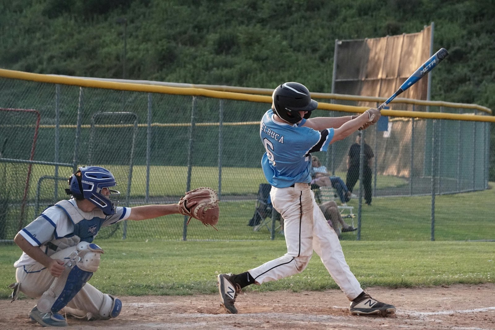 Young baseball player swinging a lightweight travel ball bat during a competitive youth game