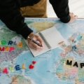 Travel planning notebook with laptop and map illustrating organized trip preparation